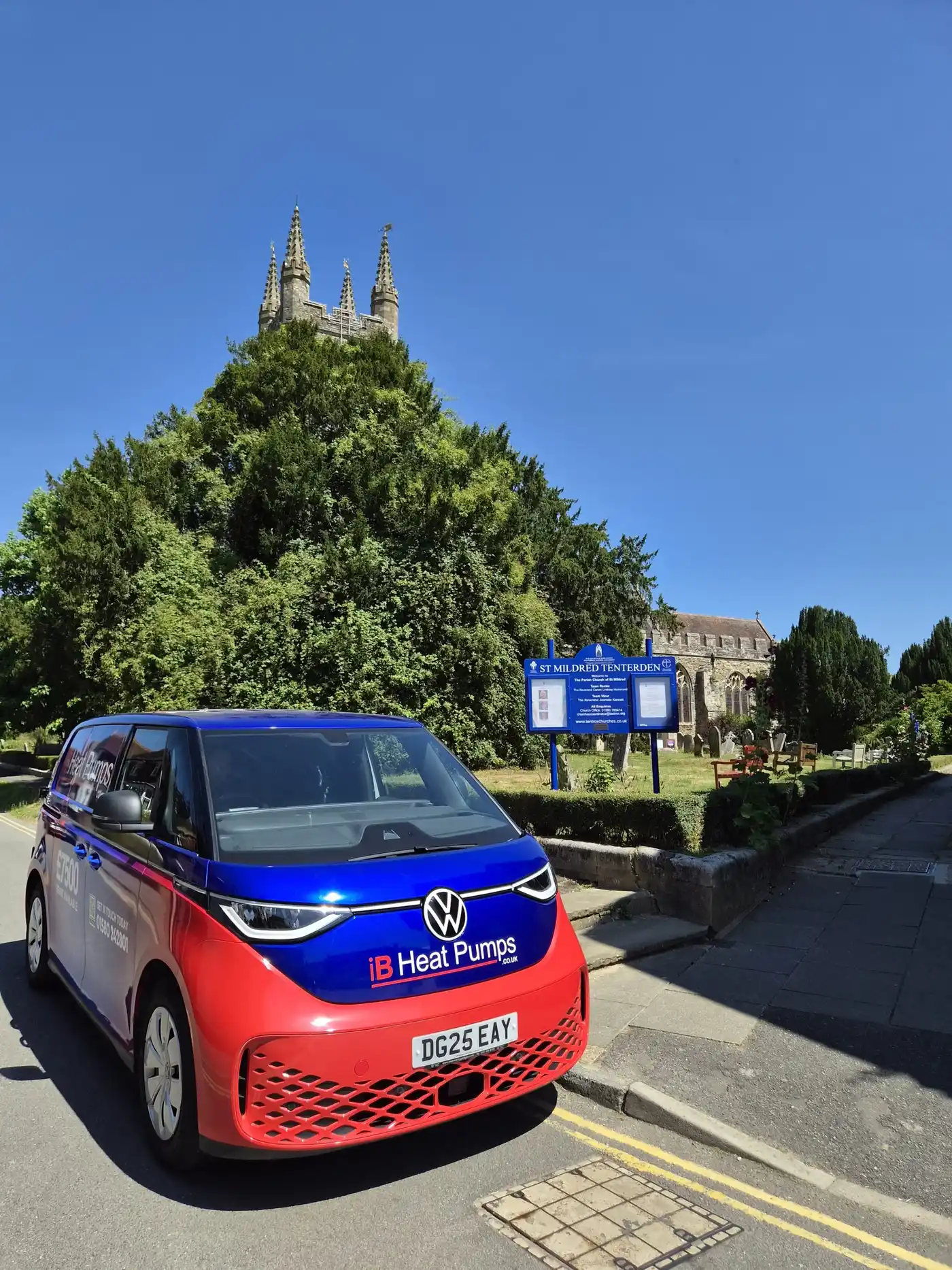 IB Heat Pumps Volkswagen ID. Buzz electric installation van parked by the St Mildred's Church sign in Tenterden, Kent.